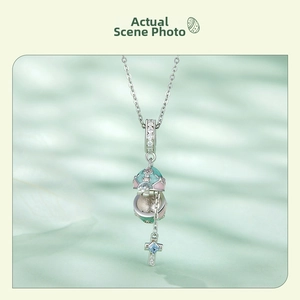 Vue macro d'un pendentif œuf de Pâques en argent S925 ouvrant avec croix et gemme