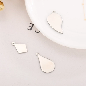 Detailed view of silver stainless steel geometric pendants in heart and drop shapes for DIY