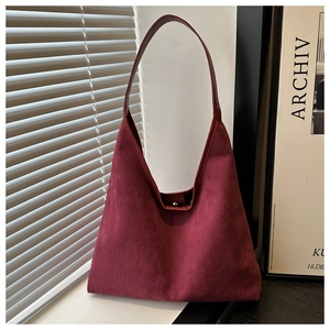 Deep red vintage tote bag with suede texture shown in an elegant room setting
