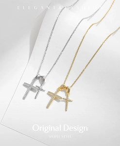 Détail de pendentifs double croix en or et argent avec zircons brillants sur chaînes en O