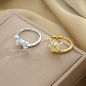 Close-up of gold and silver butterfly rings with zircon crystals on a jewelry box