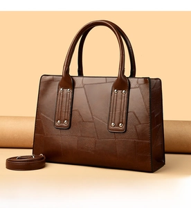 Detail of dark brown tote bag with geometric stitching and detachable shoulder strap