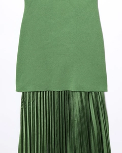 Détail du contraste entre le tricot vert et la texture satinée plissée sur la robe