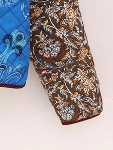 Detail of diamond quilted jacket featuring blue paisley and floral patchwork fabric