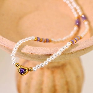 Elegant natural stone beaded necklace with a gold heart pendant and purple crystal