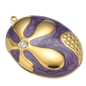 Macro view of gold-plated oval pendant with purple enamel and sparkling clear zircon