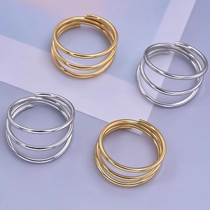 Close-up of three-layer spring open rings in gold and silver stainless steel finishes