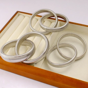 Silver flexible snake-style spring bracelets in various widths in a luxury jewelry box