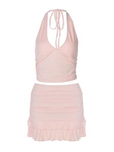 Pink two-piece set with a halter ruched top and ruffled mini skirt on white background