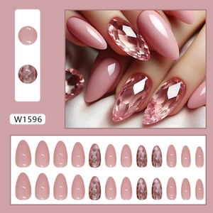 Short almond press-on nails set in nude pink with marble patterns and glitter accents