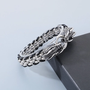 Détails des têtes de dragon en argent sur un bracelet en cuir tressé noir rétro