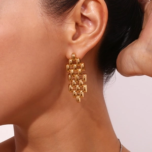 Macro detail of 18K gold-plated stainless steel watchband chain drop earrings on model