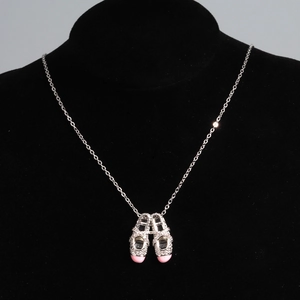 Close-up of silver necklace with pink ballet slipper pendant and crystal stones