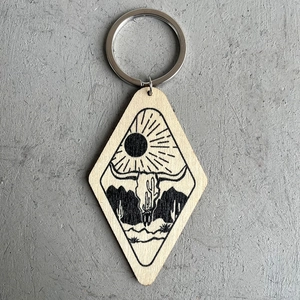 Diamond-shaped wooden western keychain with bull skull and desert cactus engraving