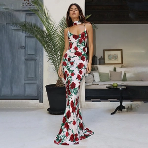 Dettaglio di abito lungo in raso bianco con stampe di rose rosse e scollo a laccio