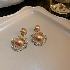 Macro detail of French vintage earrings with champagne faux pearls and zircon crystals