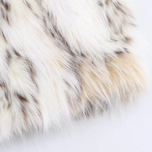Primo piano di lussuosa ecopelliccia bianca con macchie marroni e consistenza soffice