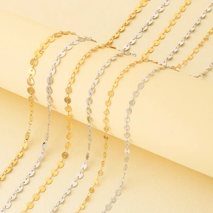 Detail view of shiny gold and silver stainless steel sequin disc chain jewelry