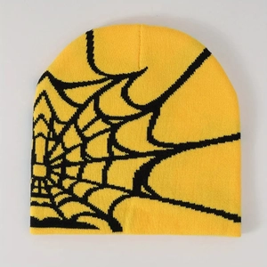 Detailed close-up of yellow knit beanie featuring black spider web pattern and texture