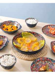 Flat lay of bohemian ceramic tableware set with colorful mandala patterns on blue base