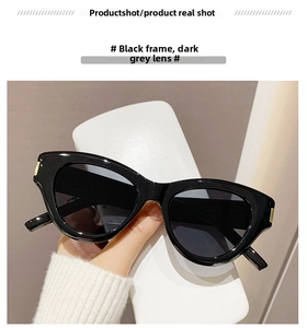 Detail of black cat-eye sunglasses with UV lenses and elegant gold metal hinge accents