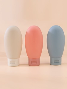 Three-piece travel bottle set in beige, pink, and blue silicone for toiletries