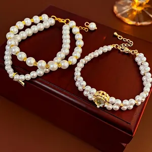 Dual-layer gold plated pearl bracelet with moonstone pendant on vintage wooden jewelry box