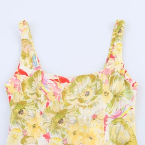 Close-up of floral print dress featuring yellow and green flowers on linen-like fabric