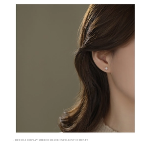Detailed close-up of S999 sterling silver eight-pointed star stud earring on a model ear