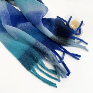 Detailed close-up of blue gradient checkered mohair scarf with soft fringe texture