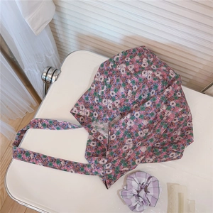Macro shot of floral canvas tote bag with pink flower pattern and hair accessories