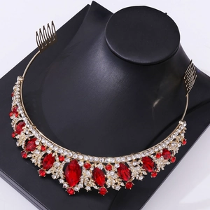 Close-up of a bridal crown featuring red oval gemstones and crystal accents on a gold frame