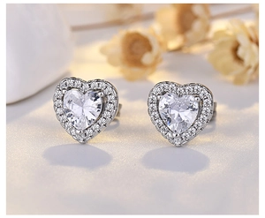 Macro shot of silver heart stud earrings with cubic zirconia halo design and clear details