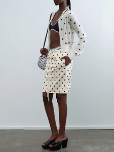Detailansicht von Polka-Dot-Midirock und Strickjacke mit Kordelzug an der Seite
