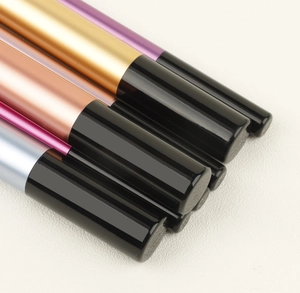 Macro shot of 7 transparent handle makeup brushes with colorful metallic ferrules in a row