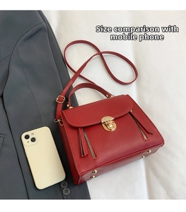 Detailed comparison of the red leather shoulder bag size next to a smartphone