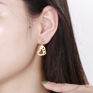 Close-up of model wearing a golden hollow heart-shaped stainless steel earring