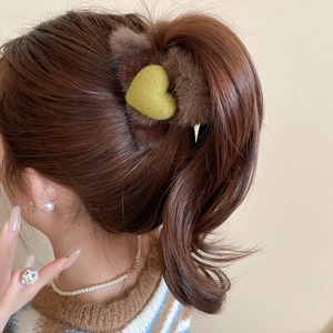 Vue détaillée d'une pince à cheveux en peluche marron avec cœur sur un mannequin