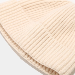 Close-up of the beige knitted beanie showing detailed wool texture and ribbed pattern