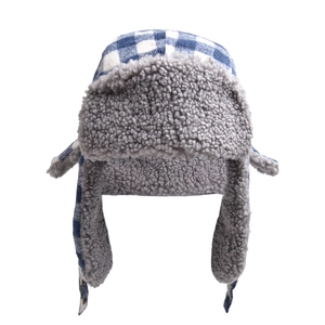 Detailed view of blue plaid trapper hat with thick grey faux fur lining and chin buckle