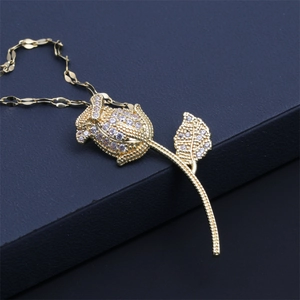 Macro view of gold rose pendant with micro-pave cubic zirconia on dark texture