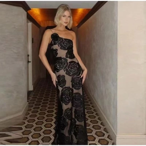 Detailed view of 3D black rose patterns on a nude mesh off-shoulder formal dress