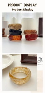 Macro shot of wide resin bangles with marbled textures in amber and caramel tones