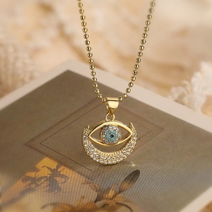 Gold plated evil eye and crescent moon pendant necklace with blue and white zircons