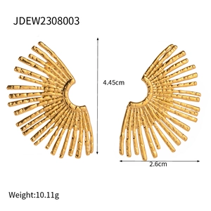 Fashionable gold stainless steel sunflower earrings with radial texture on white background