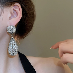 Close-up of a model wearing sparkling silver teardrop earrings with crystal rhinestones