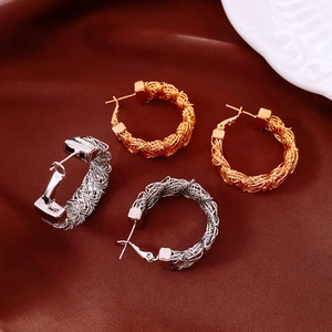 Detailed close-up of 24k gold and silver plated woven texture hoop earrings on satin
