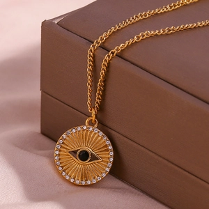 Macro shot of 18K gold plated evil eye sunburst coin pendant necklace on silk