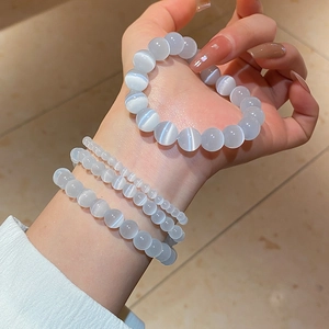 Macro shot of three cat-eye stone bead bracelets in different sizes on a model's wrist
