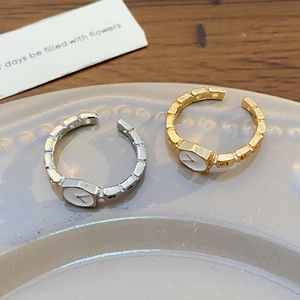 Vista dettagliata di anelli a quadrante orologio oro e argento su piatto in ceramica